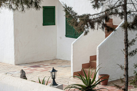 Outdoor chair beside a white Mediterranean terrace wall