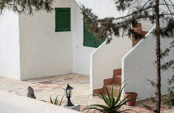 Outdoor chair beside a white Mediterranean terrace wall